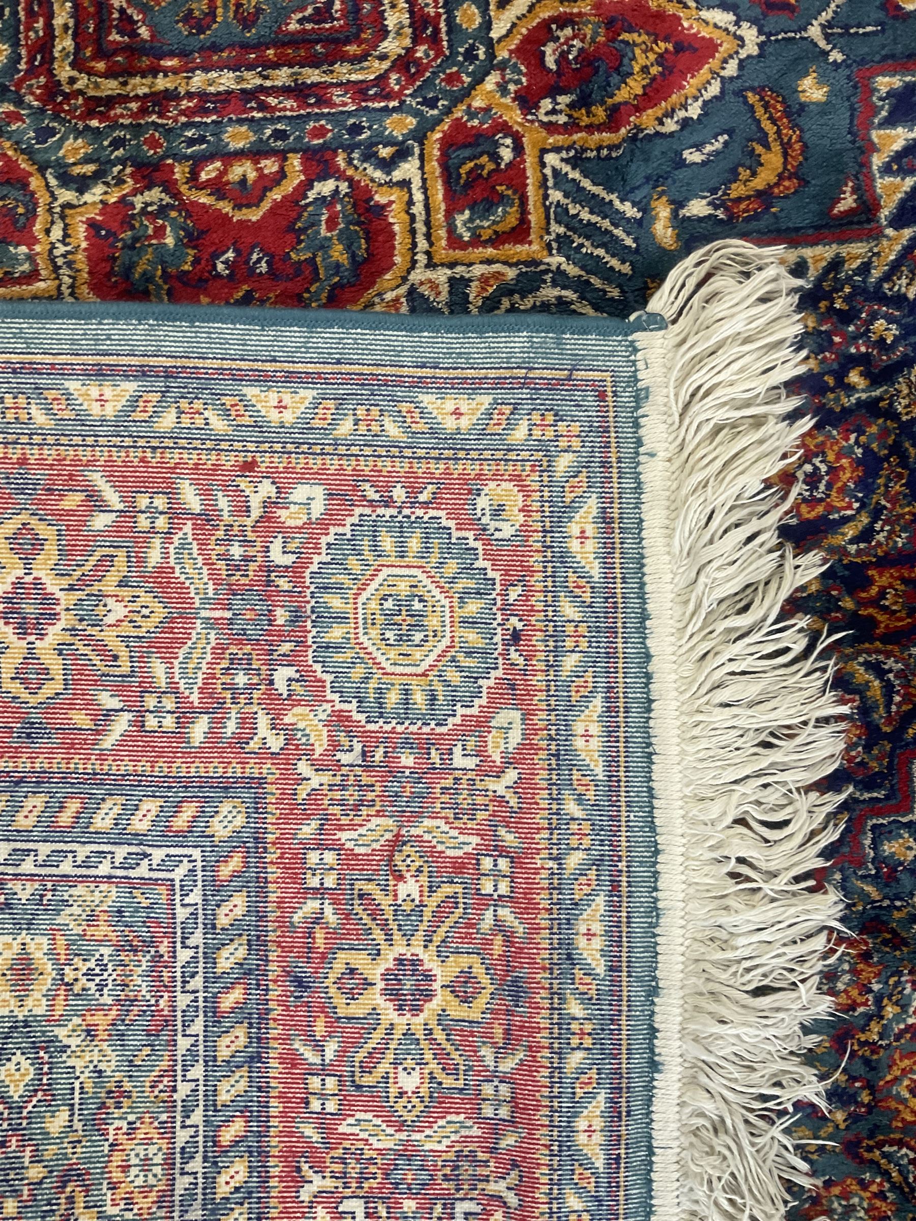 Persian design blue ground rug, the field decorated with Herati motifs and central floral medallion, repeating guarded border decorate with flower heads and trailing leafy branches 