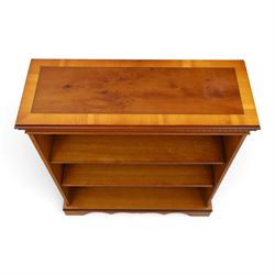 Contemporary mahogany and yew wood open bookcase, dentil cornice above two adjustable shelves, shaped apron and bracket feet 