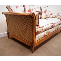  French cherry wood framed two seat settee, with moulded curing arms, bergere panels with floral upholstery, on four fluted tapering feet (W195cm) retailed by Geoffrey Benson  
