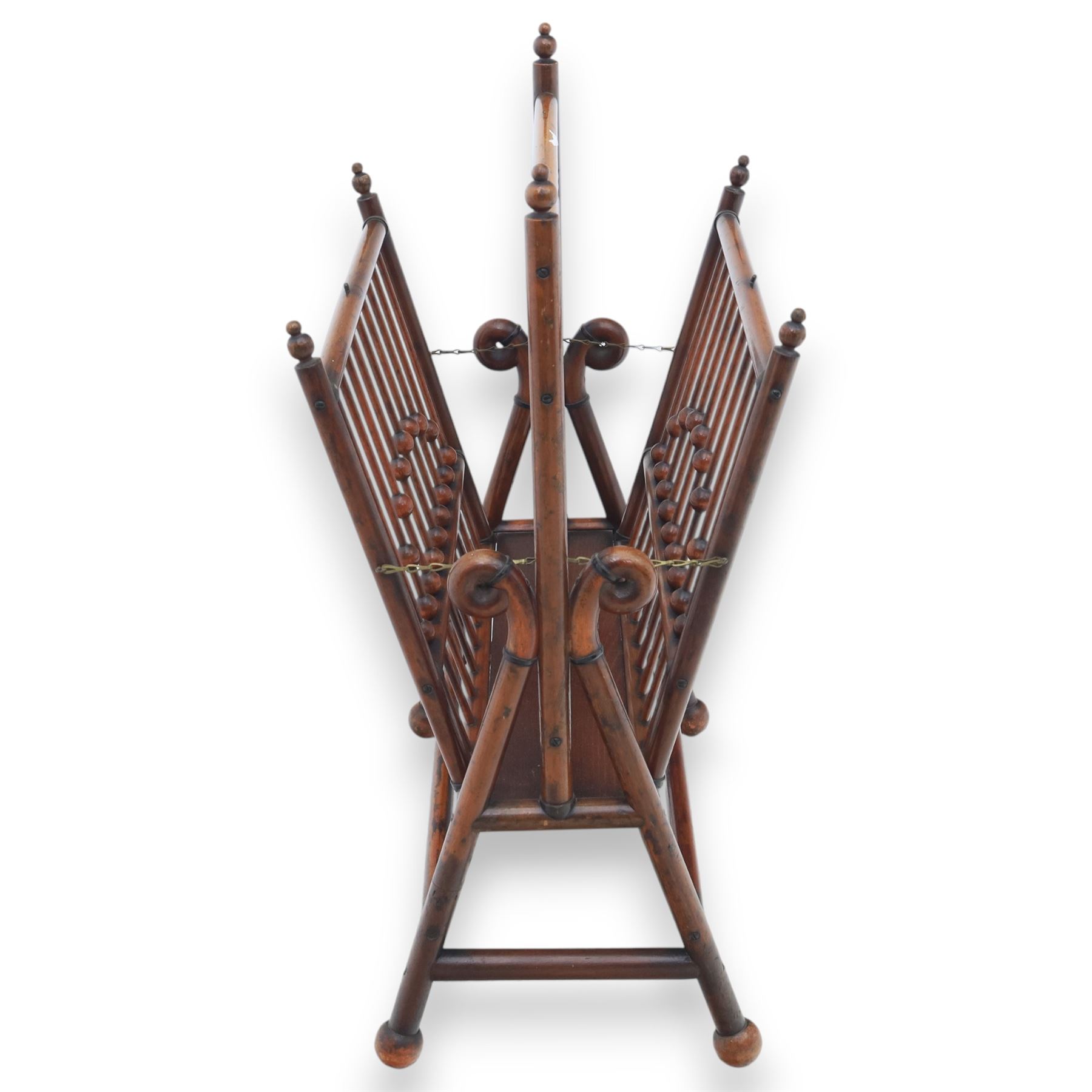 Arts and Crafts mahogany magazine stand, in the manner of Christopher Dresser, folding magazine stand, rectangular divided slatted compartments with turned spindle galleries and ball finials, the sides forming an X-frame action, raised on turned supports united by stretchers