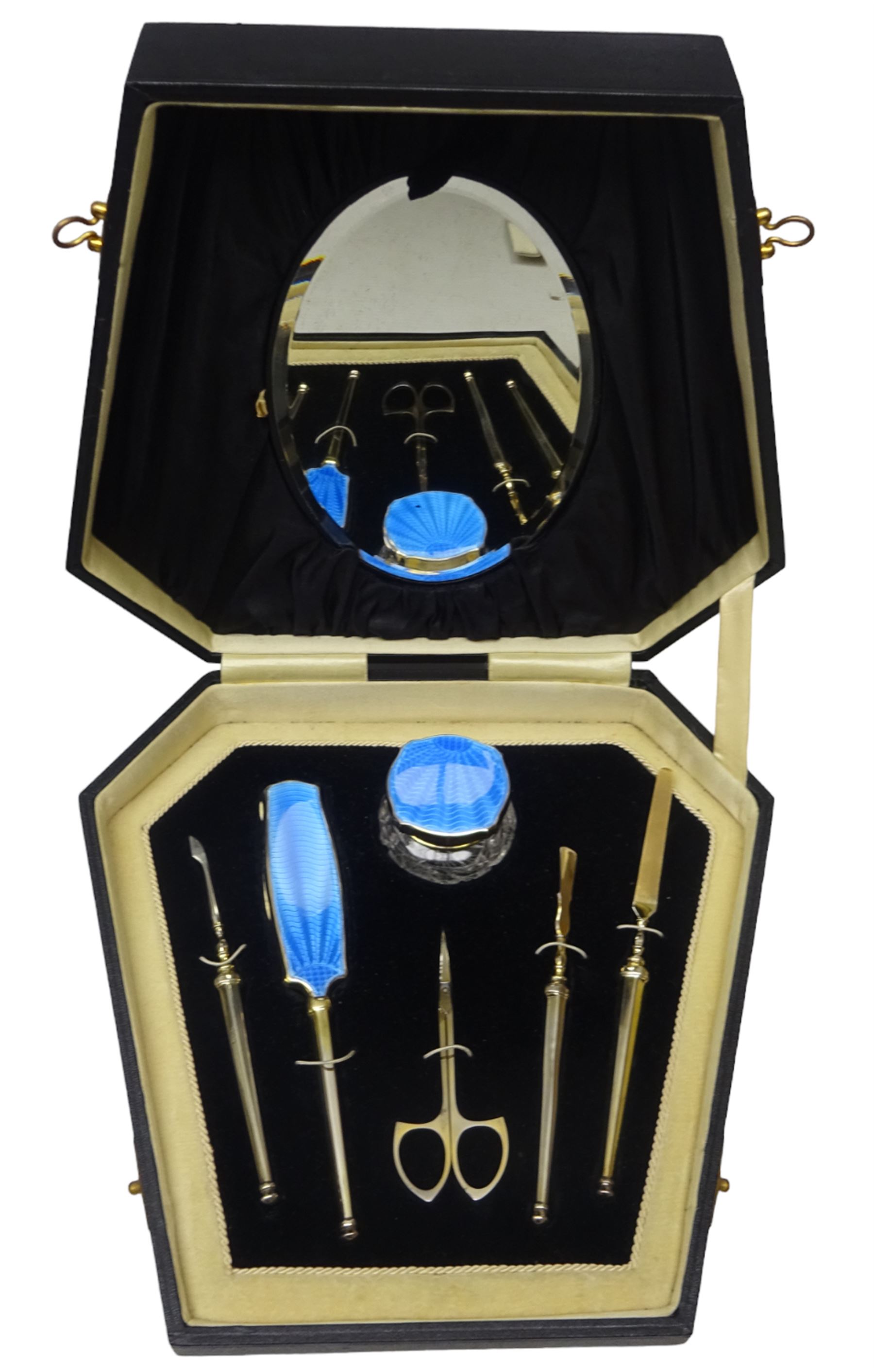 Art Deco thirteen piece silver mounted blue guilloche enamel dressing table set, comprising two hair brushes, two clothes brushes, hand mirror, two cut glass jars, buffer and a cut glass scent bottle, hallmarked J W Tiptaft & Son Ltd, Birmingham 1930 and 1932, and a silver handled manicure set, hallmarked Daniel Manufacturing Company, Birmingham 1930, with a pair of base metal scissors, each contained within three original fitted cases with black and cream silk and velvet lined interiors, one with removable mirror