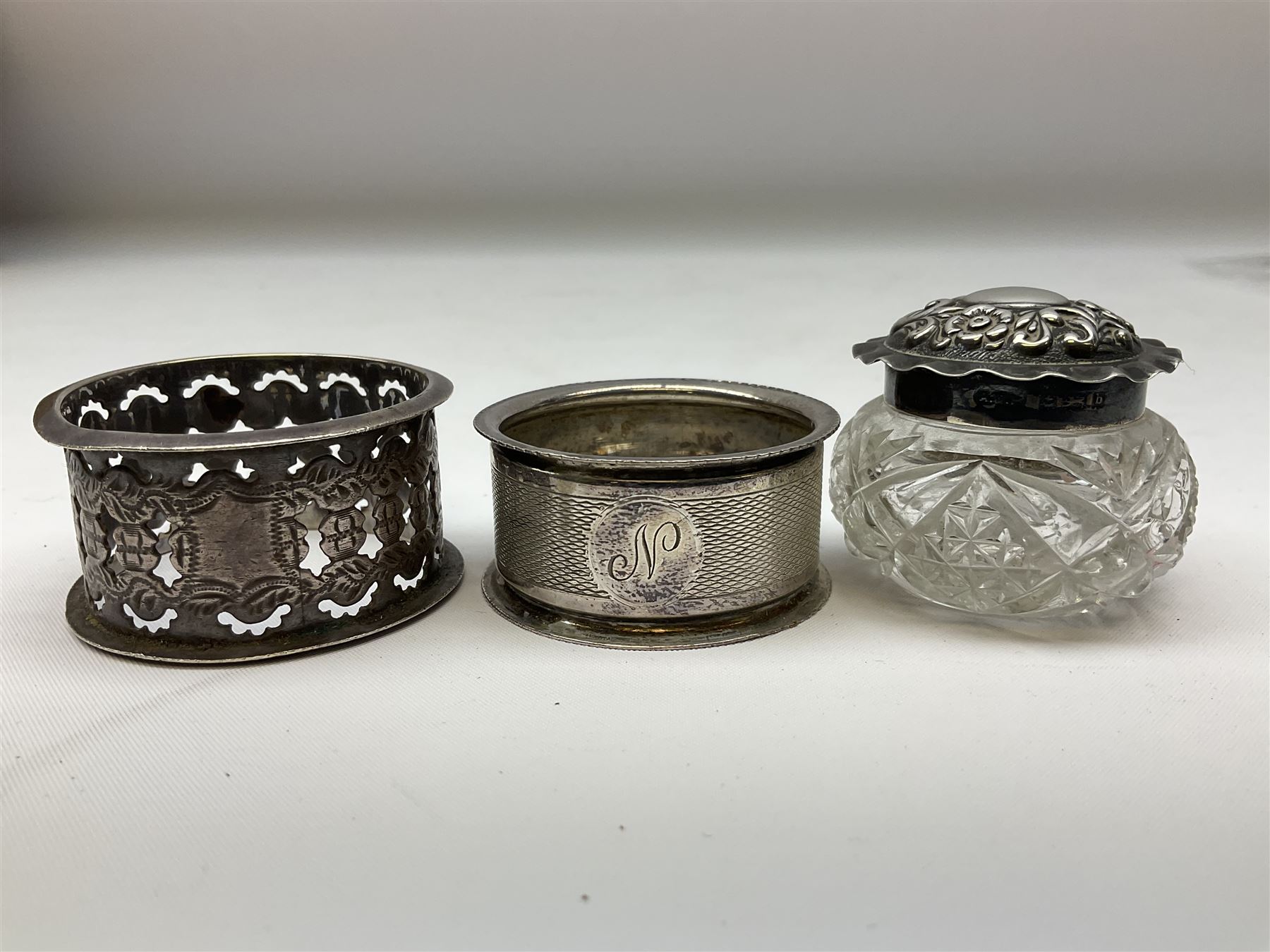 Two silver napkin rings, silver spoon with thistle top terminal, two silver handled butter knives, and small glass jar with silver cover, all hallmarked, approximate weighable silver 53.7 grams