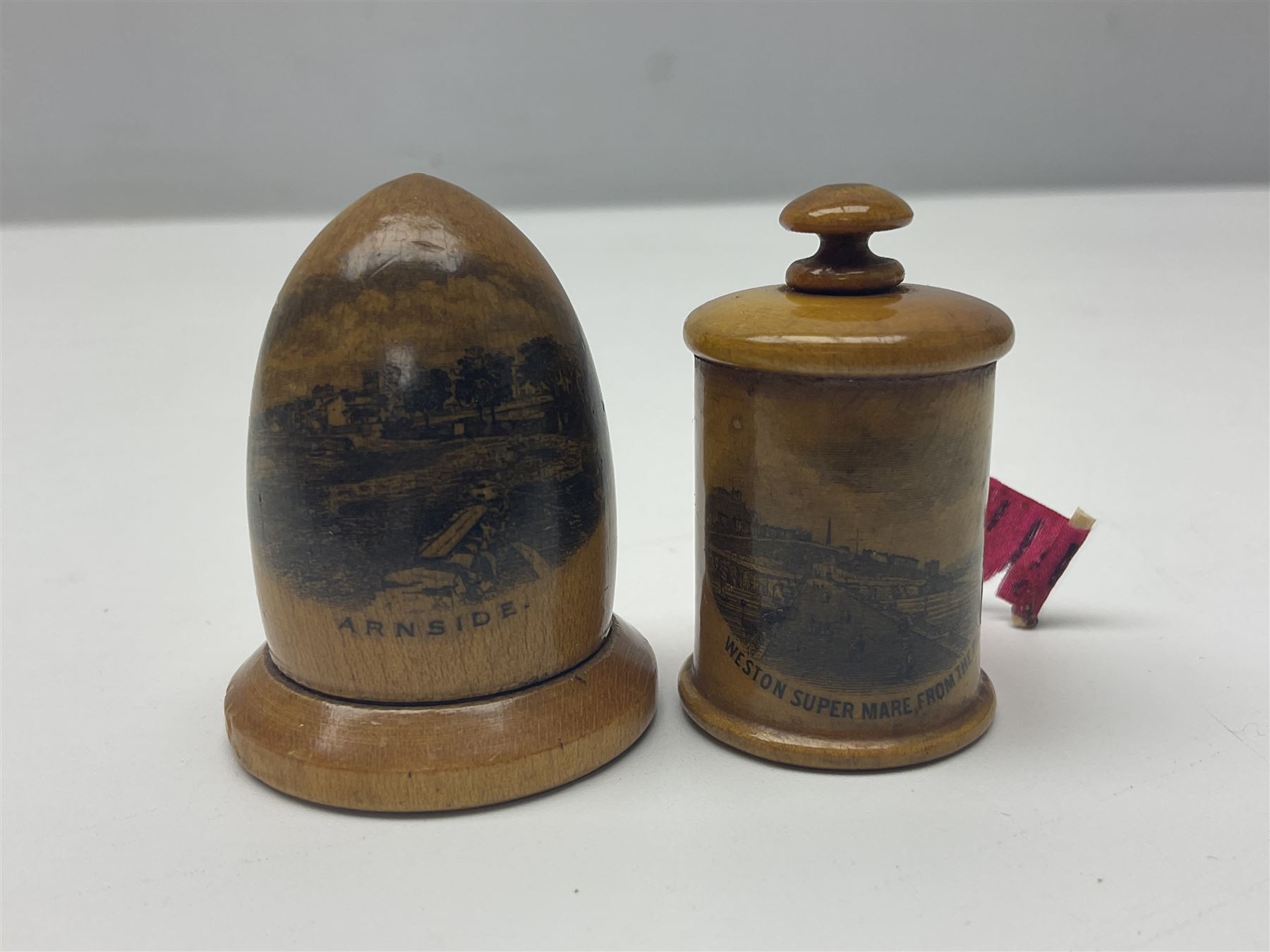 Six sewing related Mauchline ware comprising an oval reel box with internal label for Clark & Co's, tape measure, pin case and three thimble holders of ovoid form 