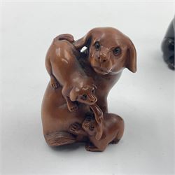 Four carved wood and composite netsuke, modelled as mouse on a basket of mushrooms, signed, dog with puppies, signed, seated pug and a composite turquoise-coloured seated pug, signed, largest H5cm (4)