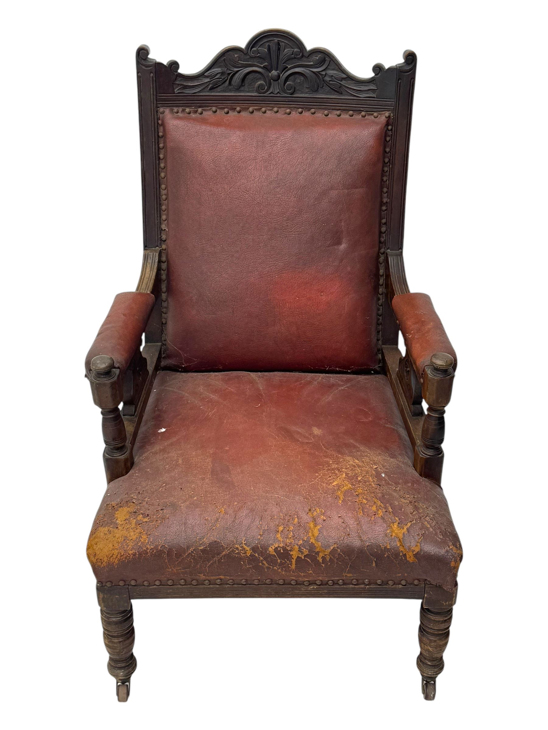 Victorian walnut framed armchair, shaped pediment carved with scrolling foliage, upholstered in leather, on ring turned front feet