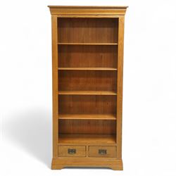Contemporary oak bookcase, with moulded cornice above open shelved interior, fitted with four adjustable shelves and two short drawers with inset brass handles, panelled sides, plinth base