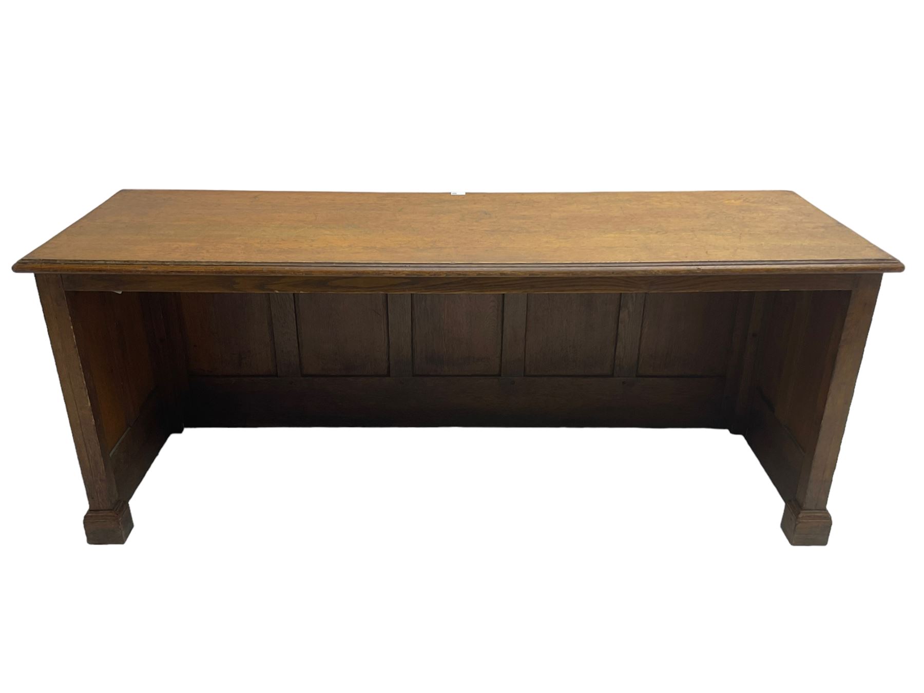 Illingworth Ingham and Co. School Furnishers (Leeds c1900) - early 20th century oak rostrum or headmaster's desk, rectangular top, the front and sides panelled with open reverse, on plinth base