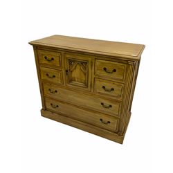 Polished pine chest, centre cupboard enclosed by six drawers
