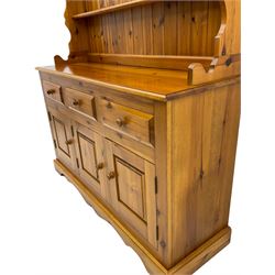 Pine farmhouse dresser with three drawers and three cupboards, and two tier plate rack