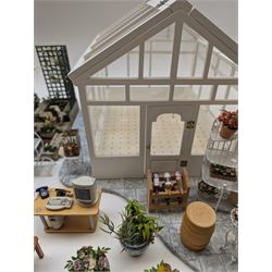 1:12 scale dolls house conservatory and garden accessories, including white wooden glazed conservatory on a stone effect base, black and white metal garden seating, barbecue, plant shelves, parasol, barbeque accessories, large planters, rabbit hutch, animals, chimenea, etc