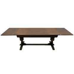 20th century oak drawer leaf extending dining table, two foliage carved baluster supports on sledge feet joined by floor stretcher 