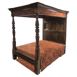 17th century and later Jacobean style oak four poster bed with canopy, the projecting canted cornice above patterned fabric frieze supported by two turned posts, the back with geometric guillouche carved frieze and three deeply recessed panels with egg and dart and other decorative mouldings, W155cm, H217cm, L220cm