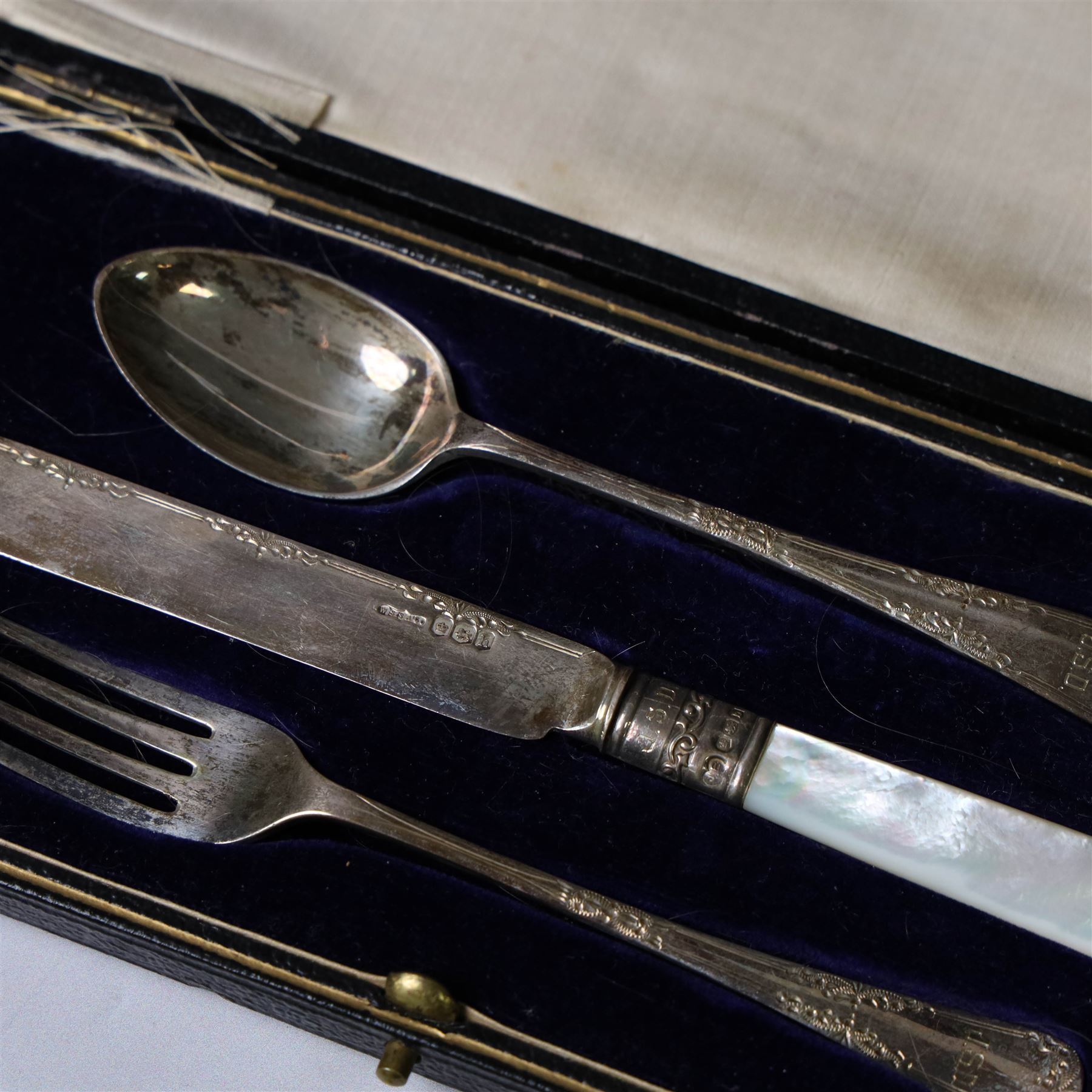 Silver Christening set, comprising spoon, fork and mother of pearl handled knife with engraved initials, together with a silver spoon and pusher set, all hallmarked, in fitted cases