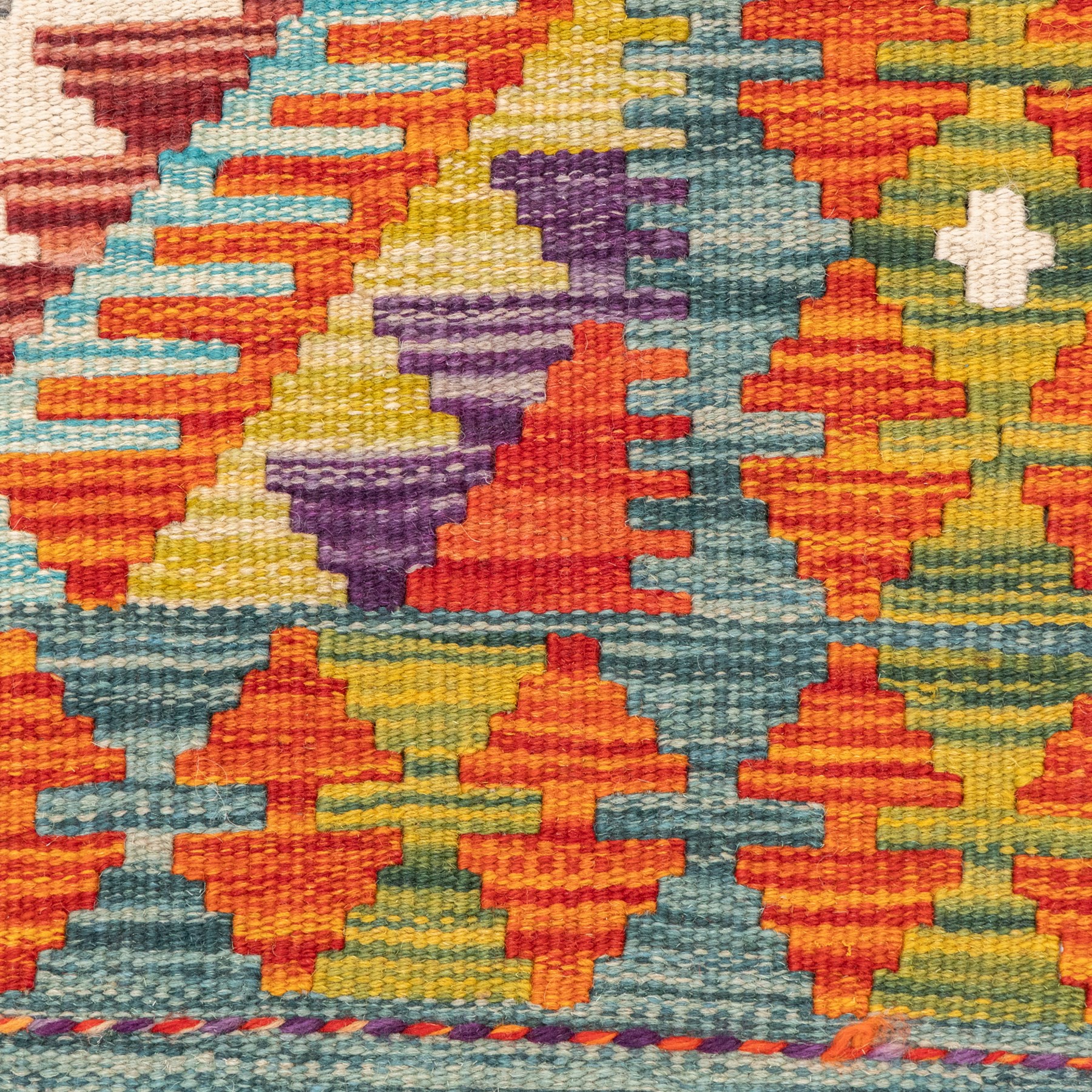 Afghan kilim amber ground runner rug, decorated a central column of repeating lozenge designs in multicolours with concentric geometric motifs, enclosed by an amber guard band with repeating diamond design