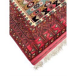 Turkaman red ground rug, the field divided into horizontal rows and decorated with geometric motifs, intricately pattern borders and end panels