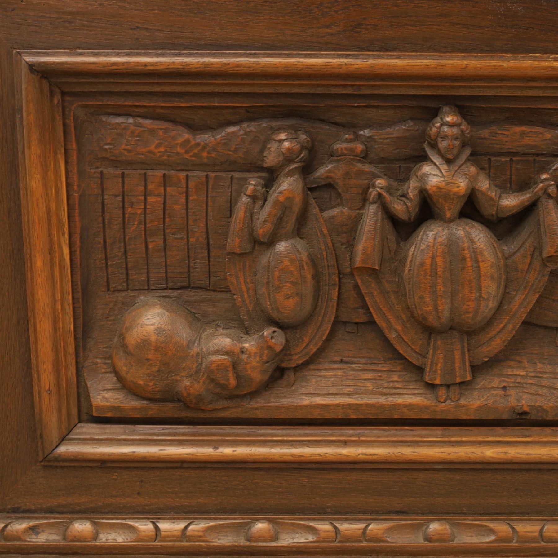 Carved oak coffer bench, rectangular moulded top above carved fall front, with figural, mask and foliate decoration, panelled sides, raised on turned bun feet with shaped lower apron