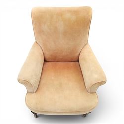 Victorian mahogany framed armchair of traditional shape, the high sprung rolled back over out-swept arms, deep sprung seat over turned feet with ceramic castors, upholstered in pale salmon pink fabric