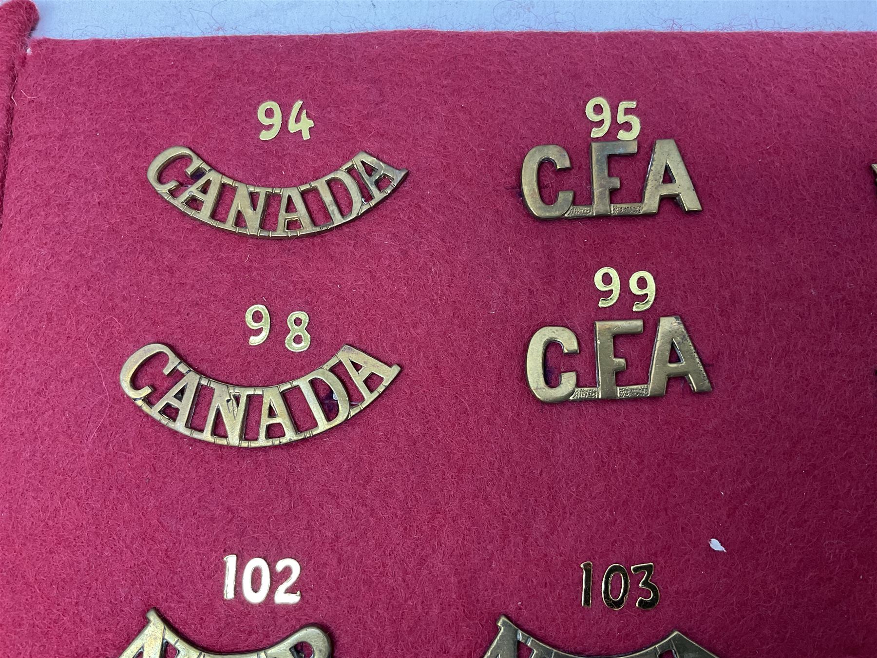 Forty glengarry and cap badges and shoulder titles including Gordon Highlanders, Canada and Canadian Field Artillery, New Zealand Field Artillery and Rifle Regiment, Shropshire Light Infantry, 14th/20th Kings Hussars, 17th Lancers, Northamptonshire Yeomanry, Royal Lincolnshire, Special Air Service, 19th Alexandra P.W.O. Hussars etc; mounted on two boards for display (2)