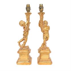 Pair of gilt cherub table lights, modelled as cherub holding aloft a torch upon a stepped ...