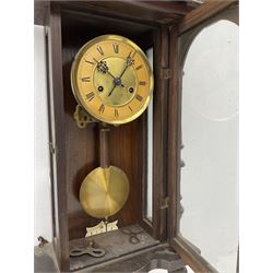 A late 19th century German wall clock c1880 with an 8-day HAC spring driven movement striking the hours on a coiled gong, in a mahogany case with a tall pediment and deeply turned columns flanking a full-length glazed door, with a two-part dial with a gilt centre and ivorine chapter, with Roman numerals, minute track and pierced gothic designed hands, spun brass faced pendulum and beat plate. With Key.



