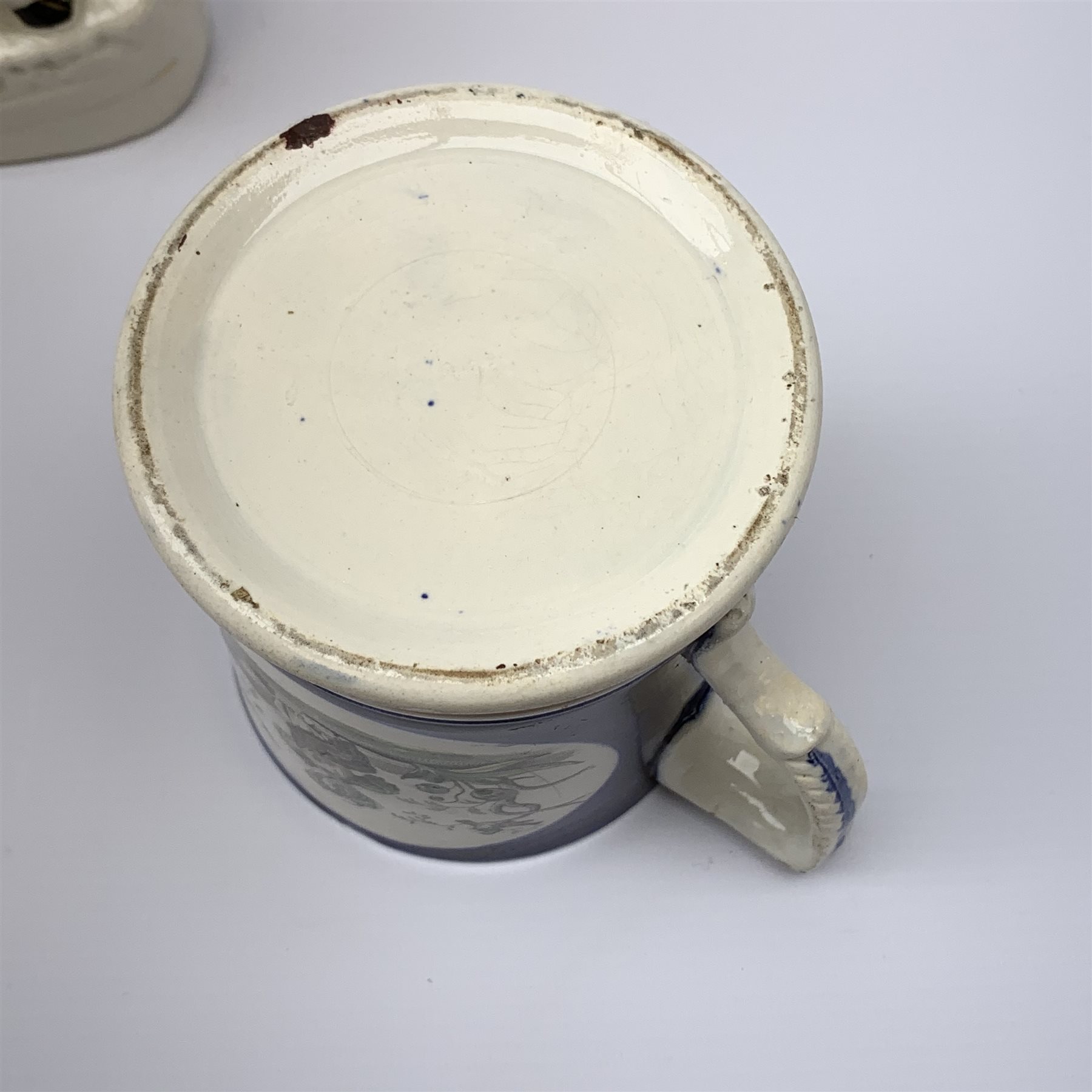 An early Victorian earthenware frog or surprise mug, decorated with printed and overpainted figural panels, H11cm, together with a 19th century child's plate detailed with a figural scene and inscribed Father Matthew administering the total abstinence pledge, 17.5cm, and a Staffordshire flat back figure seated upon a horse, H33cm. 