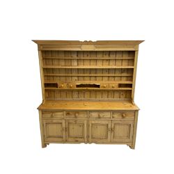 Traditional rustic pine dresser, projecting cornice over three-tier plate rack and space drawers, fitted with four drawers over four panelled cupboard doors