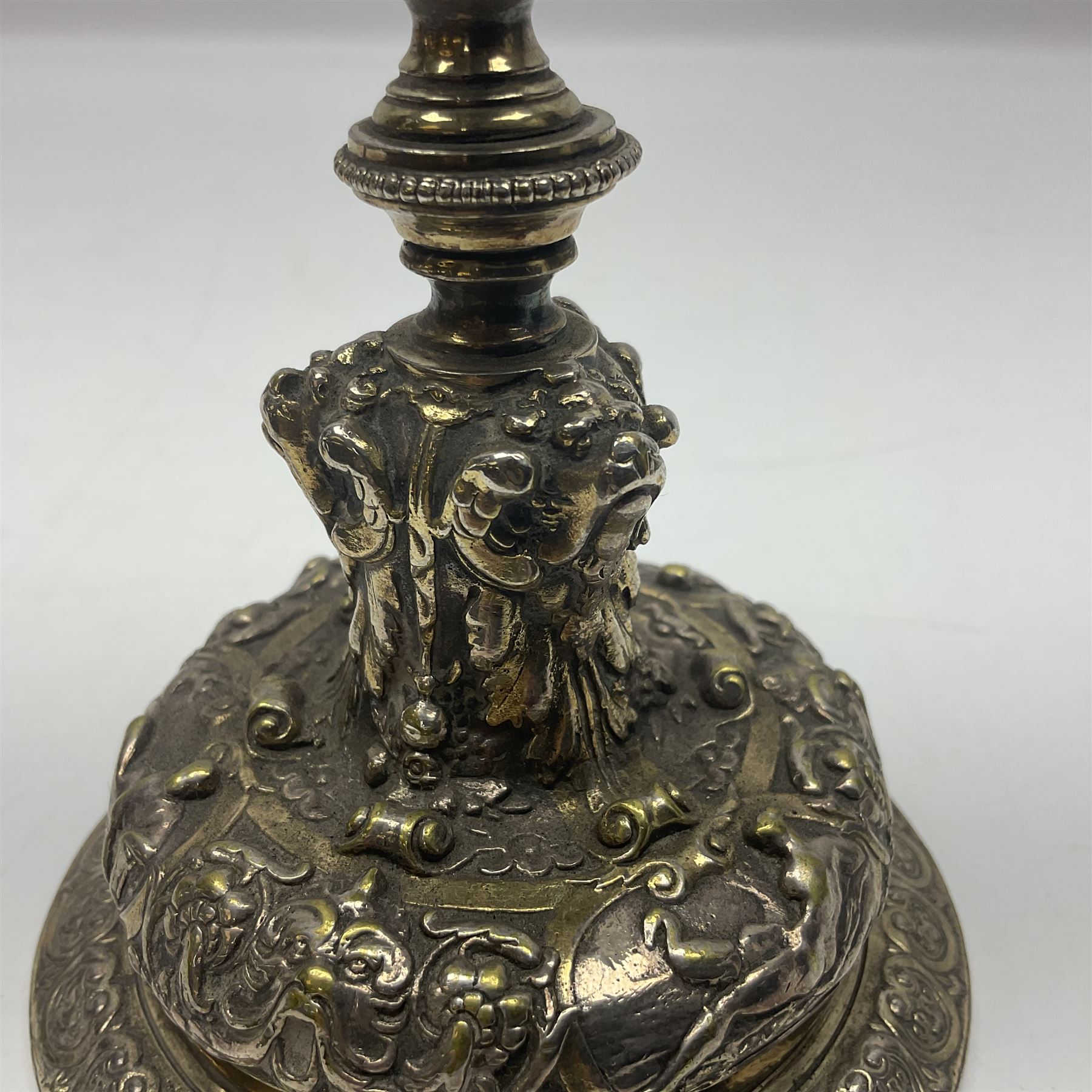 Pair of Victorian Elkington Mason & Co silver plated candlesticks, decorated in relief with ram masks and figures, H14cm