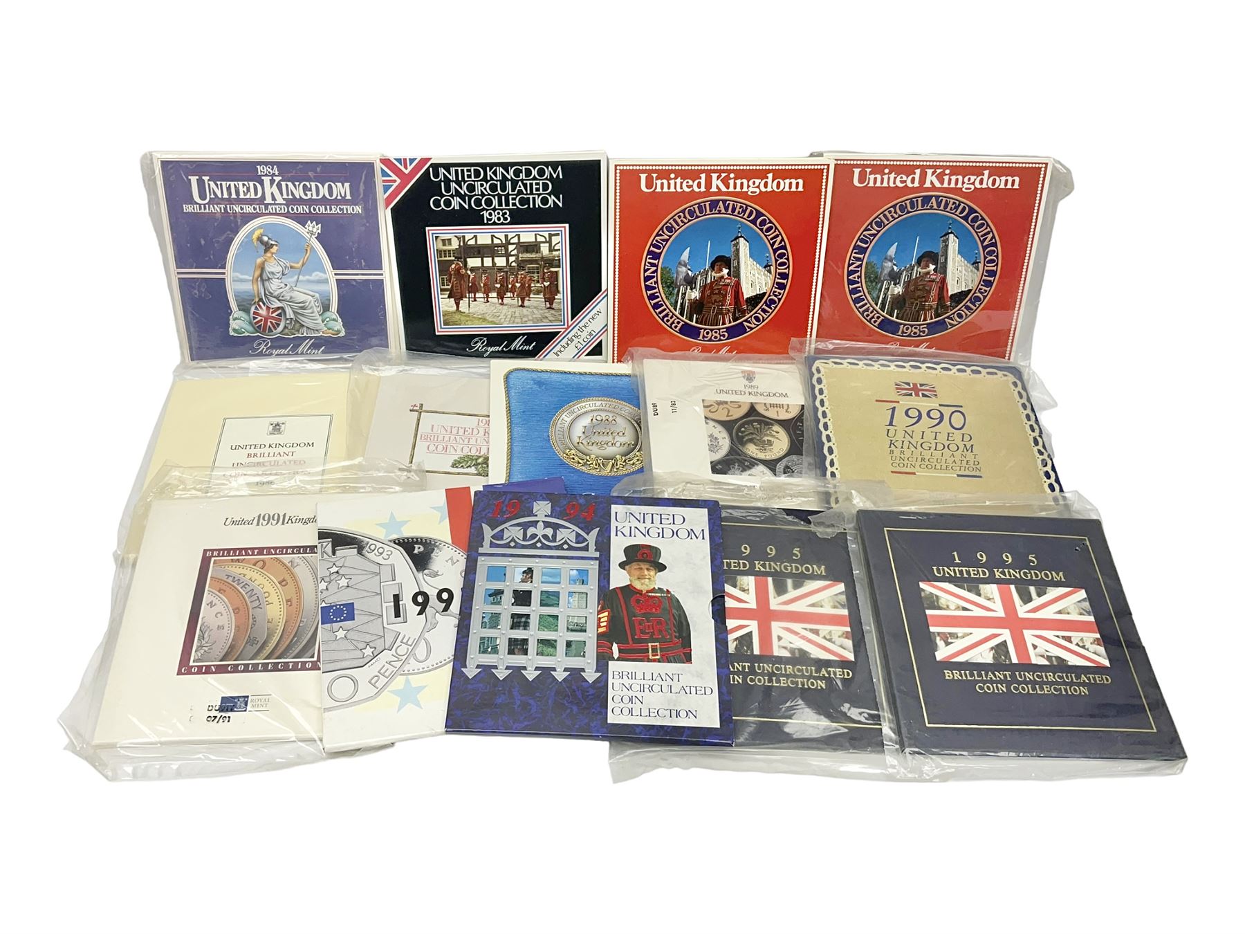 Fourteen Queen Elizabeth II United Kingdom uncirculated coin collections, dated 1983, 1984, two 1985, 1986, 1987, 1988, 1989, 1990, 1991, 1992 including dual dated 1992/1993 EEC fifty pence, 1994 and two 1995, all in card folders