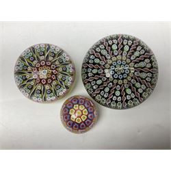 Three millefiori paperweights, together with a green glass dump paperweight with air bubble inclusions, Caithness Daisy and Cauldron paperweights and two small Caithness glass vases, tallest H9cm