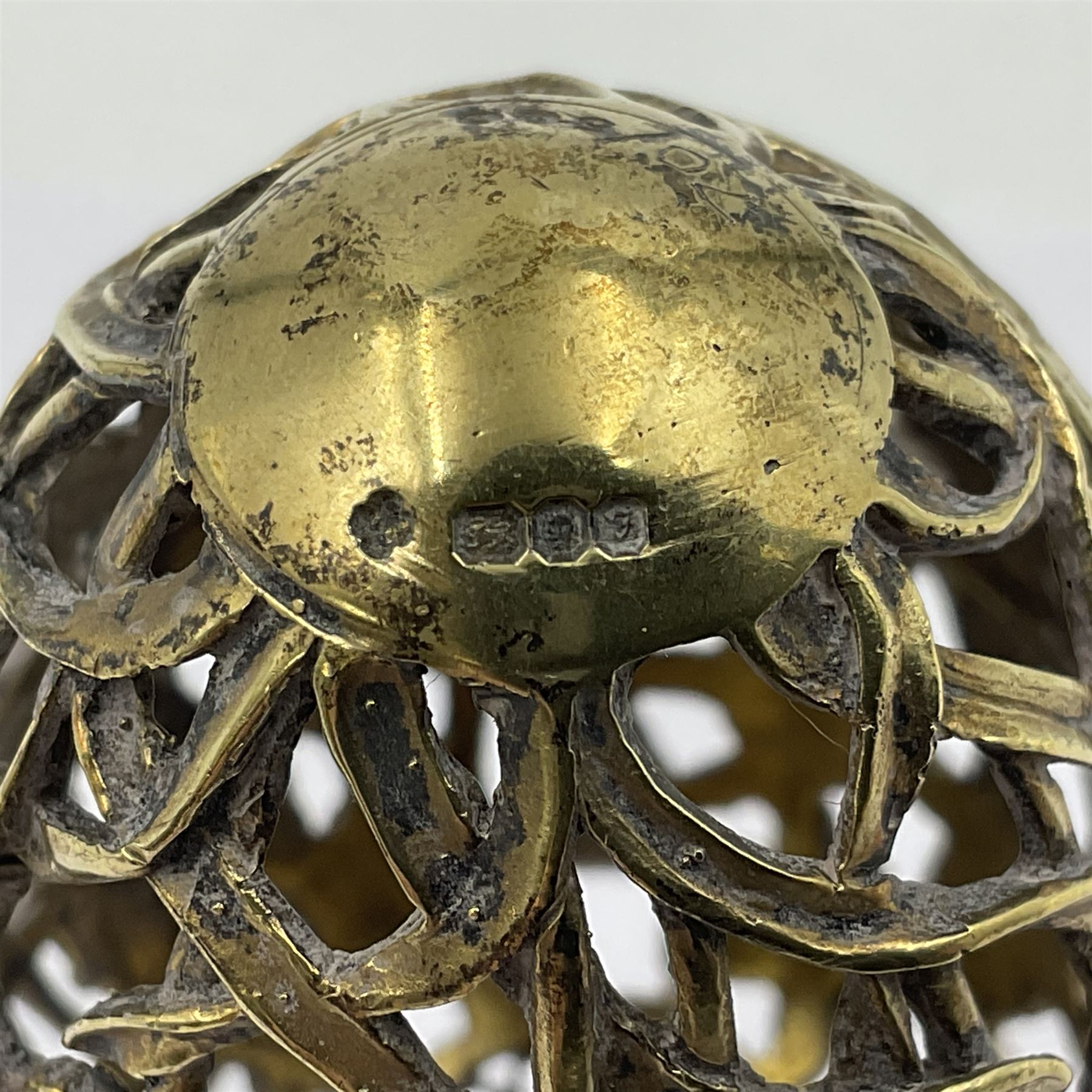 Modern silver limited edition Easter egg, no. 70/500, the gilt openwork body decorated with daffodils and detachable cover with pierced circular panel set with a single faceted blue stone, opening to reveal a gilt interior, upon silver stand with three scrolling pad feet, each hallmarked St James House Company, London 1980, height including stand 8cm