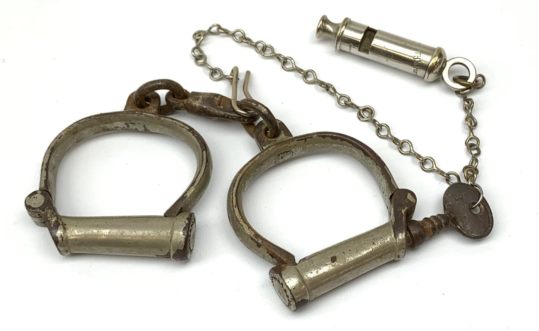 Pair of 1920's Hiatt nickel plated handcuffs marked 'Warranted Wrought' with screw-in key and a 'Metropolitan' whistle