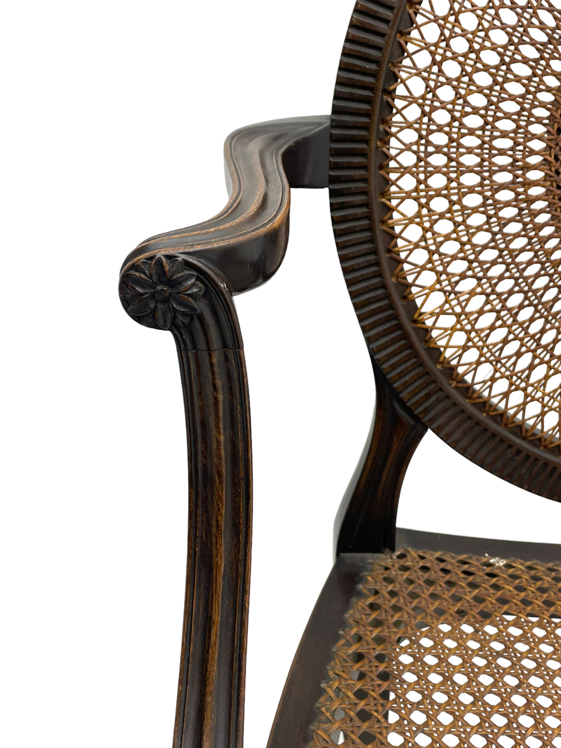 Mid-to late 20th century walnut Hepplewhite design elbow chair, circular cane back with pierced and carved central rosette, fluted frame with scrolling arms, cane seat raised on fluted rail and square tapering supports with spade feet