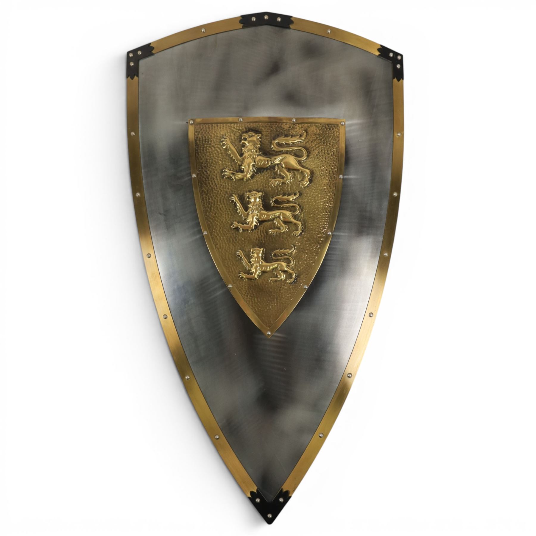 Five wall hangings, modelled as shields, decorated to the centre in relief with three lions 