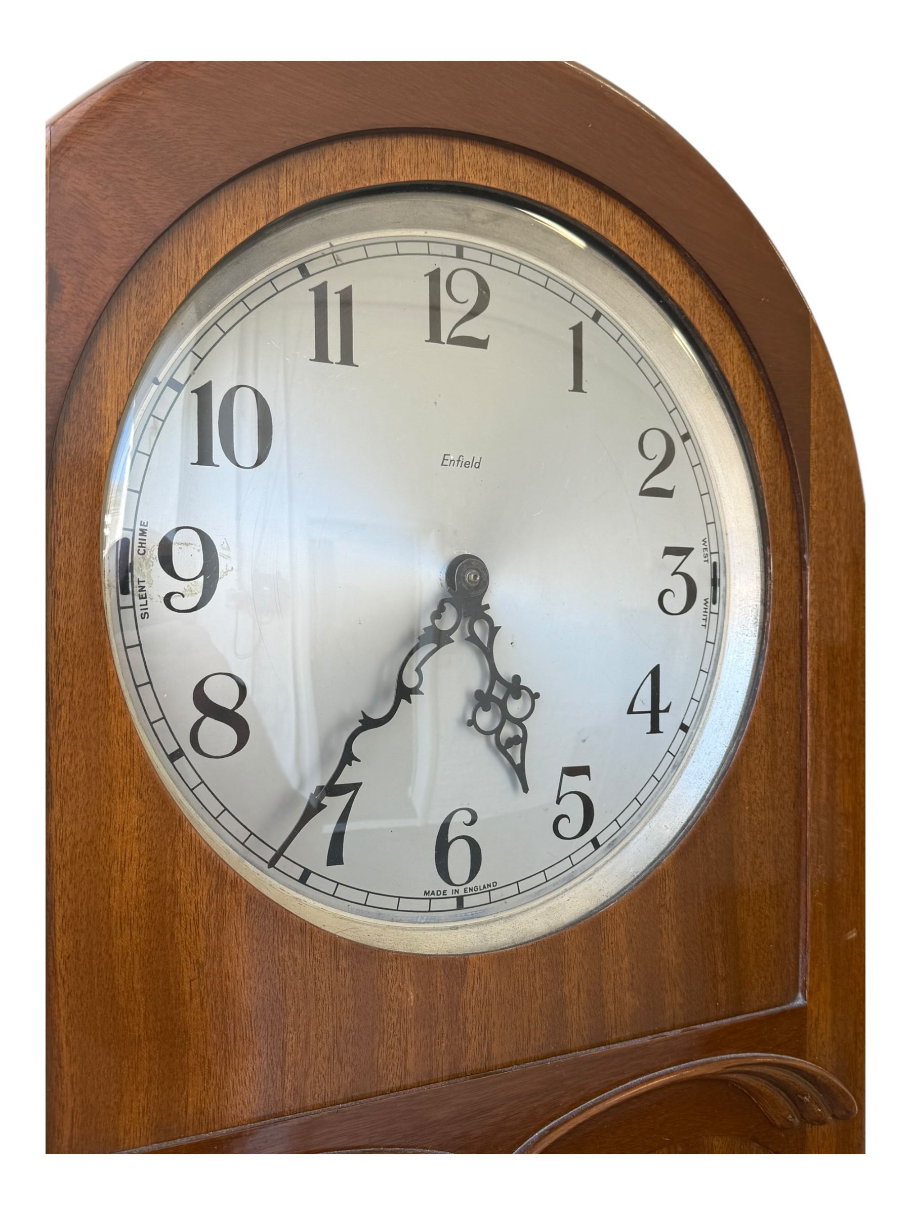 English- Art deco mahogany 8-day longcase clock, with an arched top and fill length fully glazed door beneath, on a short plinth with bracket feet, three train chain driven movement with visible stainless steel cased weights and pendulum, silvered dial with Arabic numerals, minute track and pierced steel hands, quarter chiming movement with  Westminster/ Whittington/ strike/silent selection.
