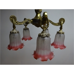  Early 20th century five branch cast brass electrolier, fitted with adjustable cranberry and clear frosted frilled glass shades, H66cm excluding chain suspension   