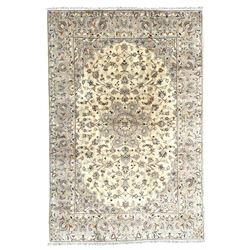 Persian Kashan ivory ground rug, the central floral medallion surrounded by interlacing branches and stylised flower head motifs, guarded border decorated with a scrolling foliate pattern