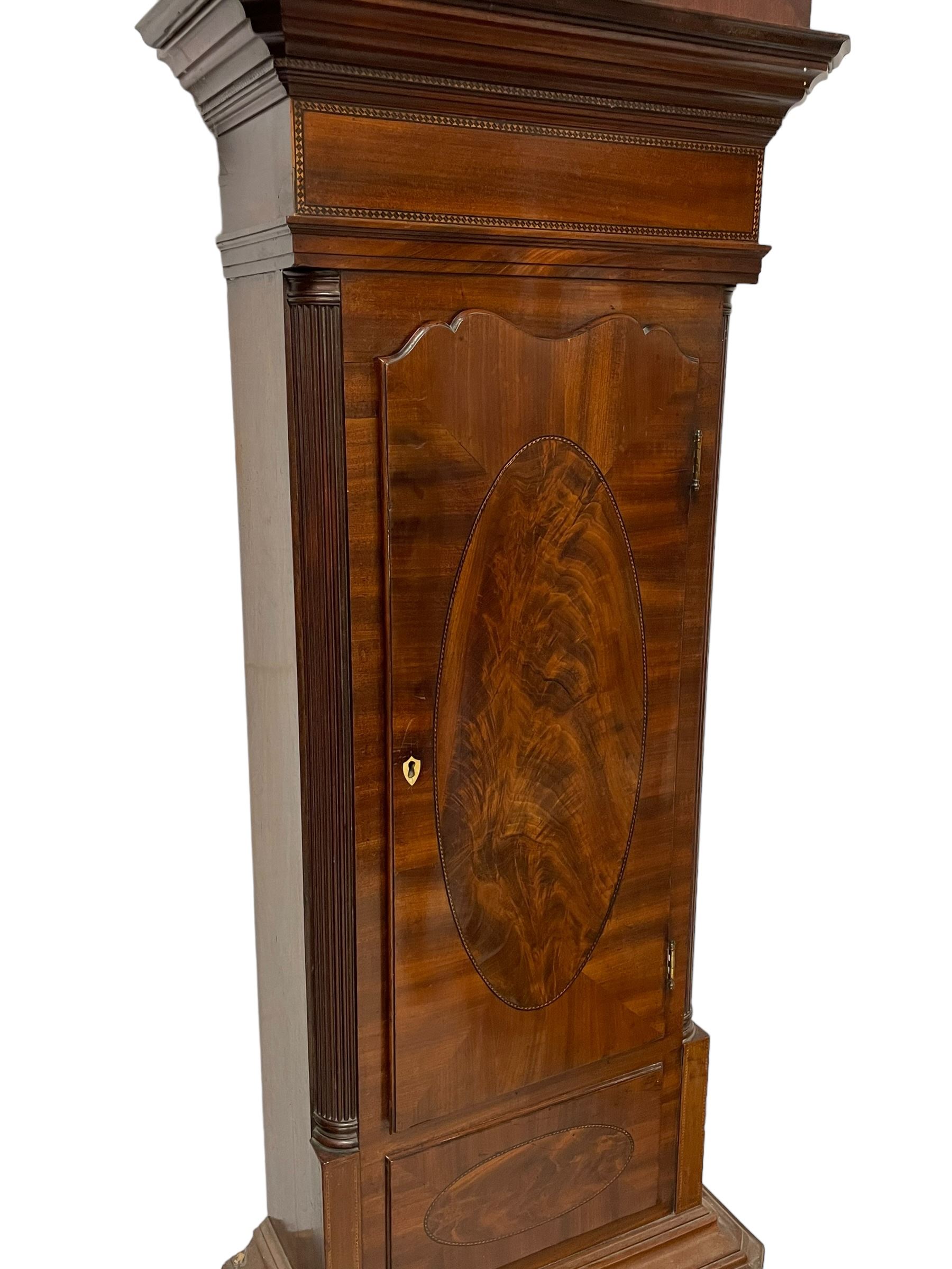 John Morgan of Aberystwyth - fine George IV mahogany 8-day longcase clock c1820, with a raised swan necked pediment, ball and eagle finial and deep inlaid frieze beneath, square hood door with a glazed circular wooden bezel and canted corners, long trunk with reeded quarter columns and a wavy topped door, rectangular plinth on bracket feet, circular painted dial with Roman numerals, minute track, makers name, and brass stamped hands, rack striking four pillar movement with a recoil anchor escapement, striking the hours on a bell. With weights and pendulum. 
John Morgan is recorded as working in Aberystwyth 1816-35. 