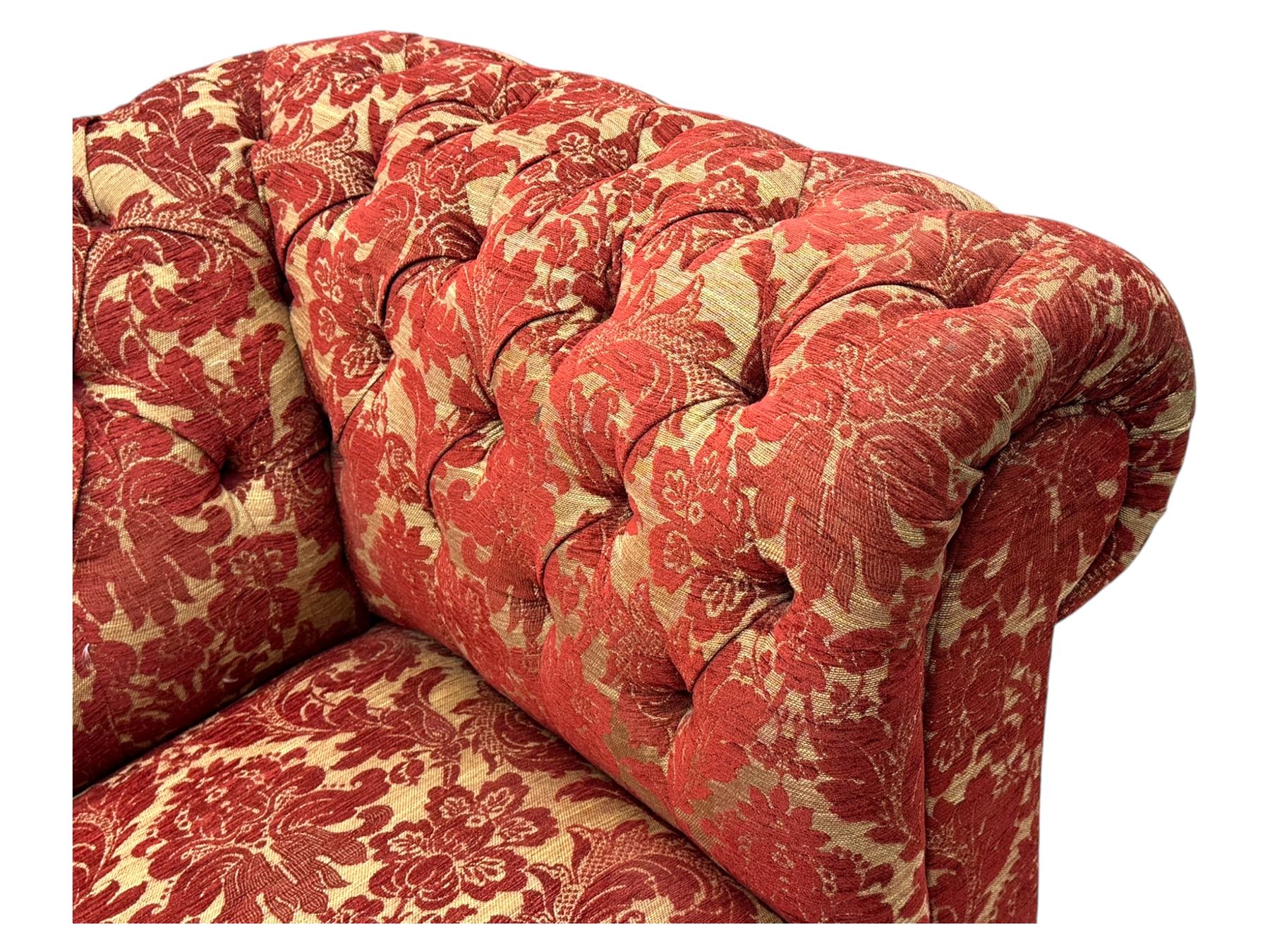 Late 20th century upholstered Chesterfield sofa, in red damask floral fabric, with deep buttoned back and arms, scrolled arms at equal height to back, on turned front supports