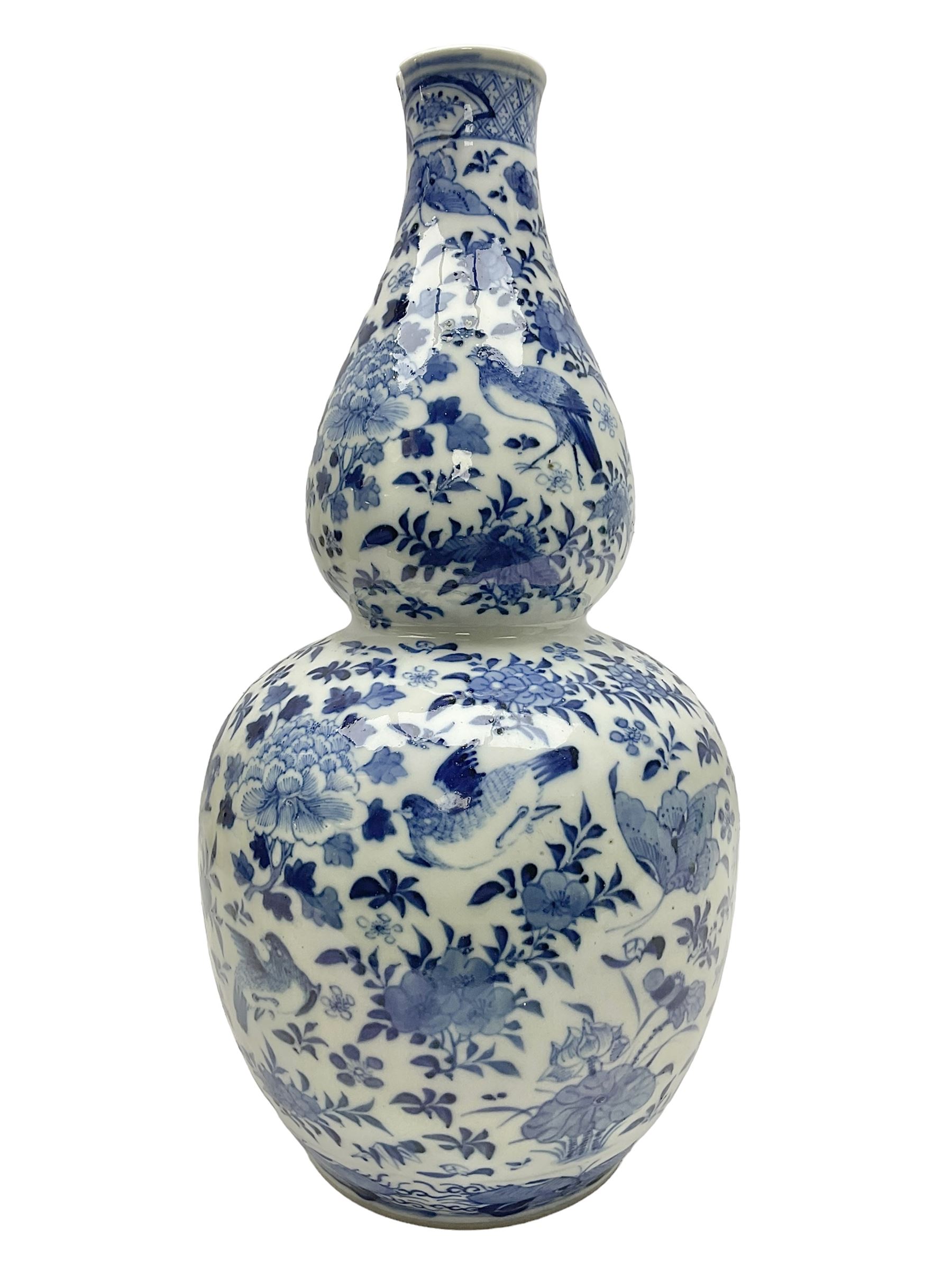 19th century Chinese blue and white double gourd form vase, decorated with blooming peonies and birds in flight, H36cm