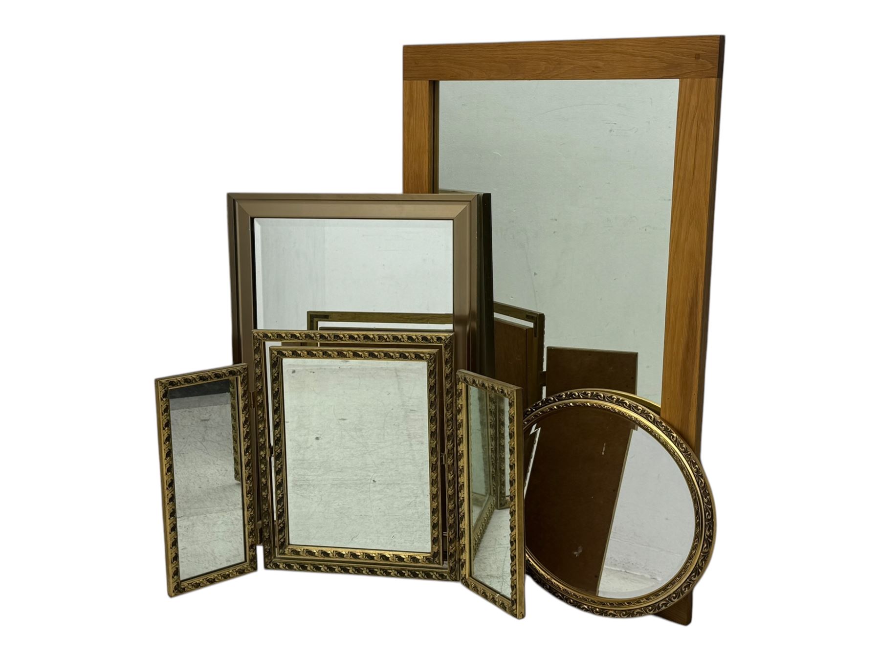 Four decorative mirrors, including gold-toned triptych dressing mirror with foliate borders, two rectangular framed mirrors and a circular gilt mirror with ornate edging