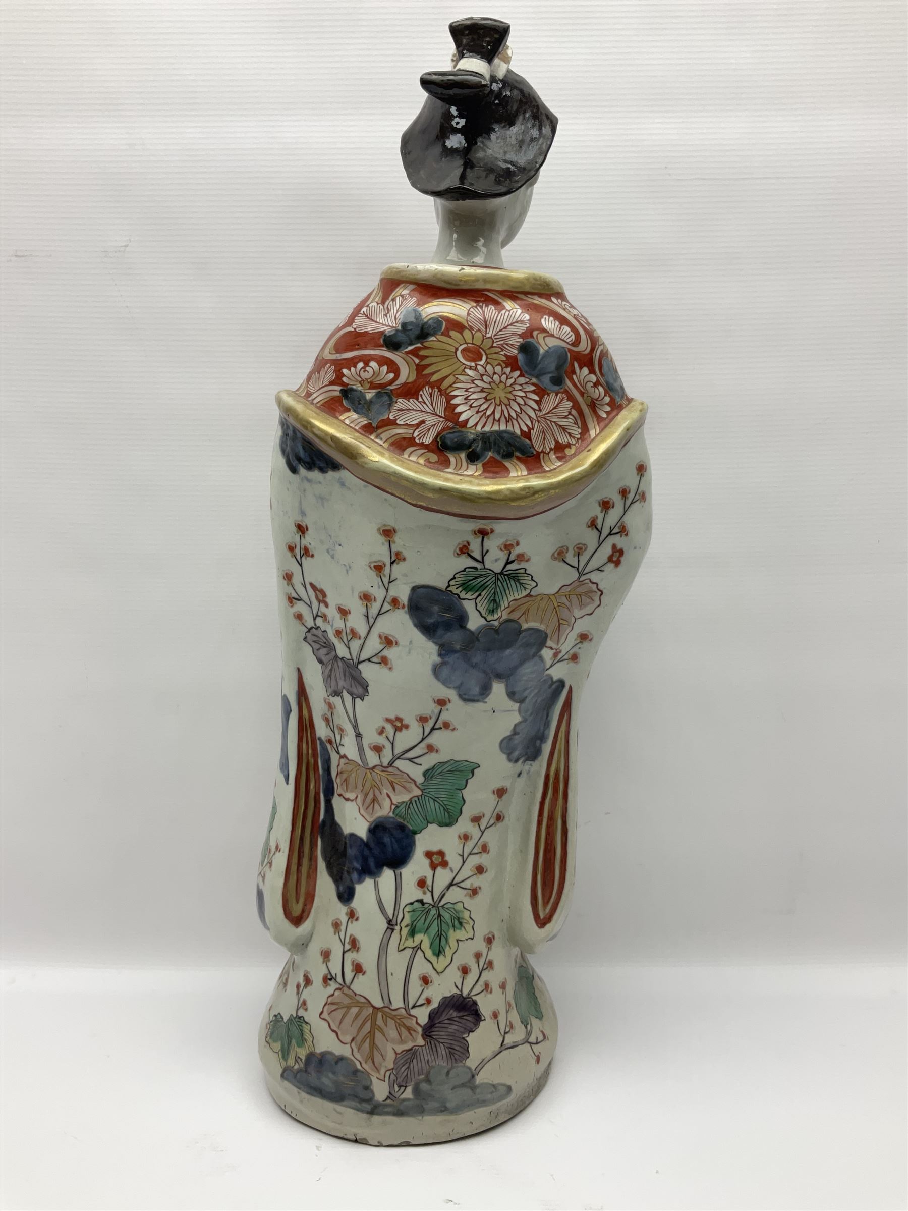 Large Japanese Imari porcelain figure, modelled as a Bijin, wearing a long kimono decorated with apple blossom and leafy branches on a white ground, with gilt detailing, possibly Edo period, H63cm