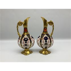 Pair of mid 20th century Royal Crown Derby Imari 1128 pattern Kedleston ewers, each with gilt scroll handle and neck, upon a gilt quatrefoil foot, each with printed marks beneath, H25.5cm