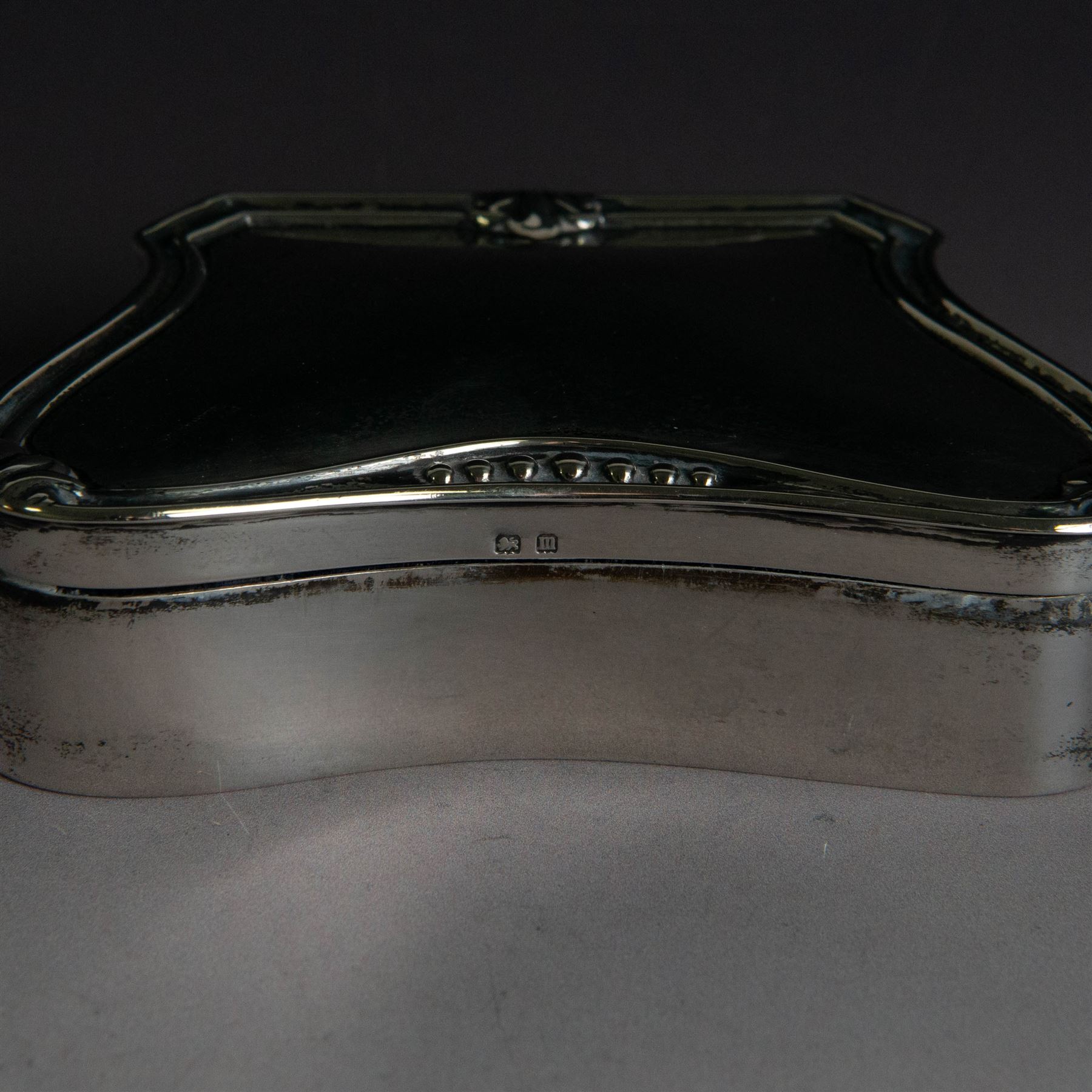 Early 20th century silver mounted jewellery box, with curved front and embossed palmette rim, opening to revel padded interior with weighted base, hallmarked A & J Zimmerman Ltd, Birmingham 1911, H3cm, W11cm