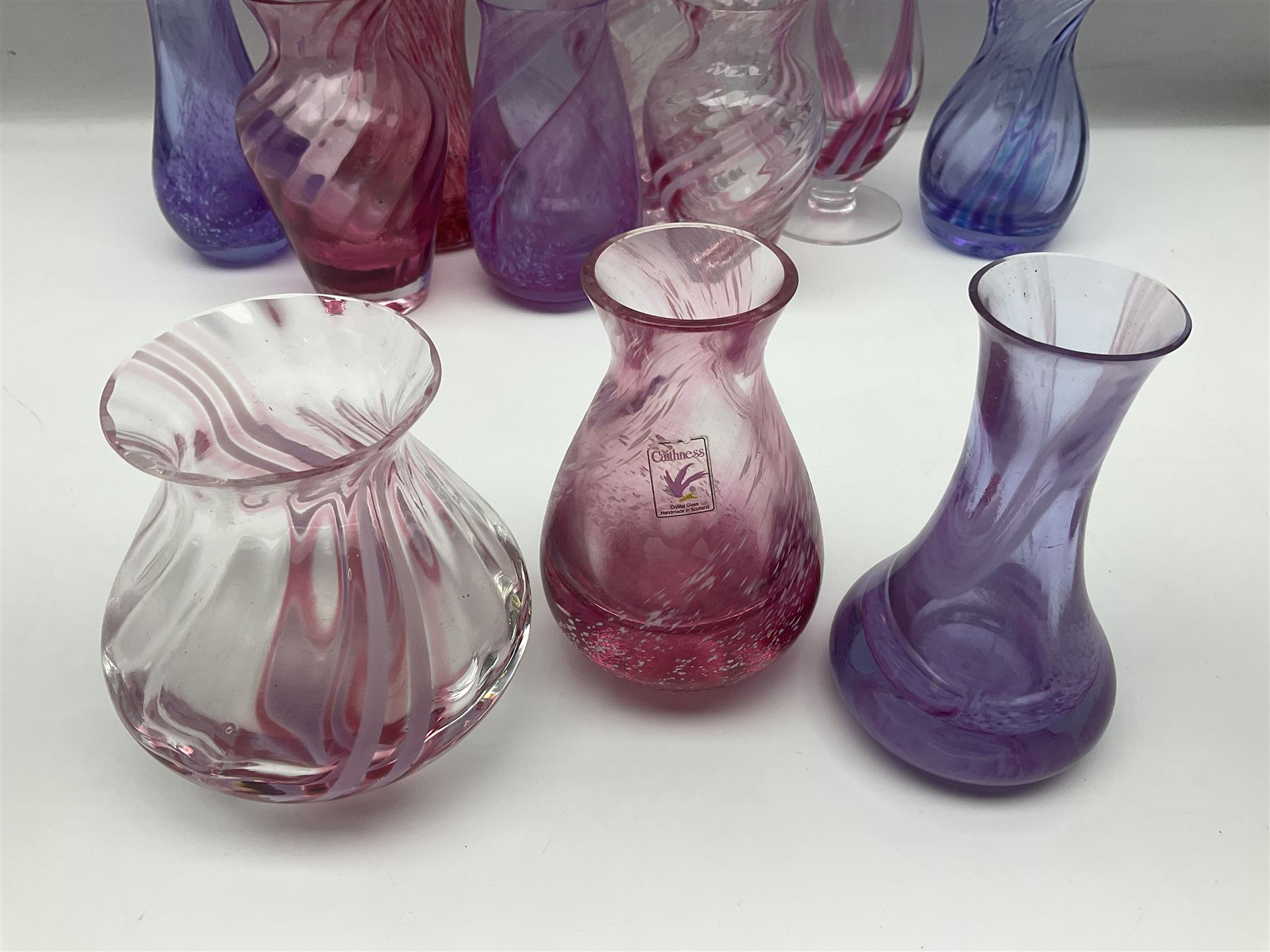 Collection of pink/purple Caithness glass vases, to include mottled and swirl designs, largest 20cm (19)