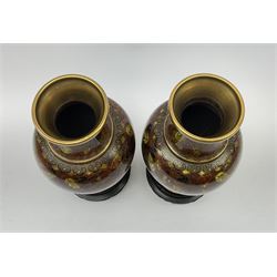 A pair of 20th century Japanese cloisonné vases, of baluster form decorated with flowers and foliage in tones of brown, with pierced wooden stands, not including stands H21cm.