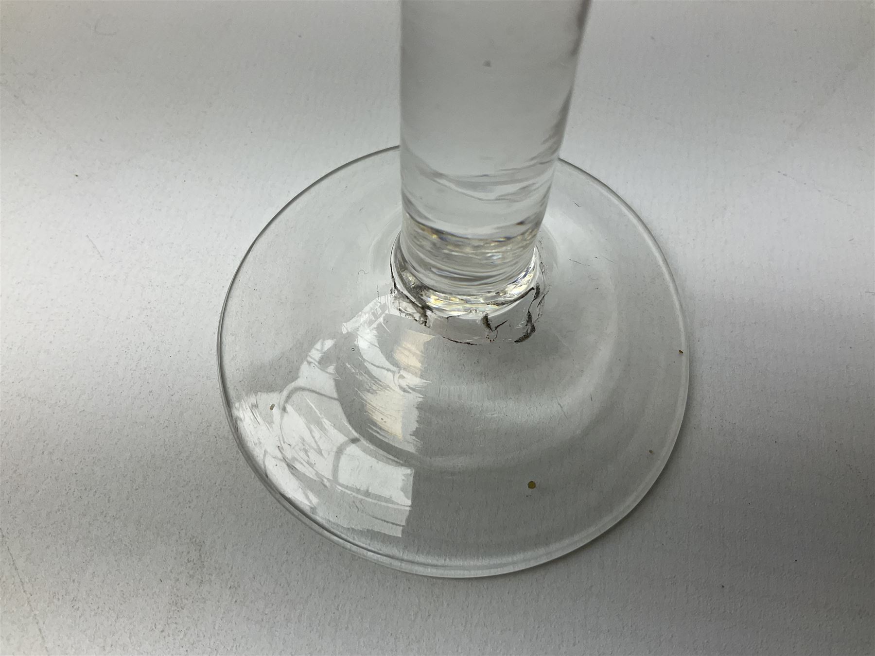 18th century drinking glass, the bell shaped bowl raised upon a plain