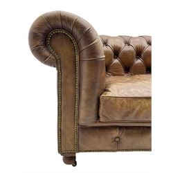 HALO - Chesterfield style two seat sofa upholstered in buttoned brown leather with stud work, on turned feet with castors