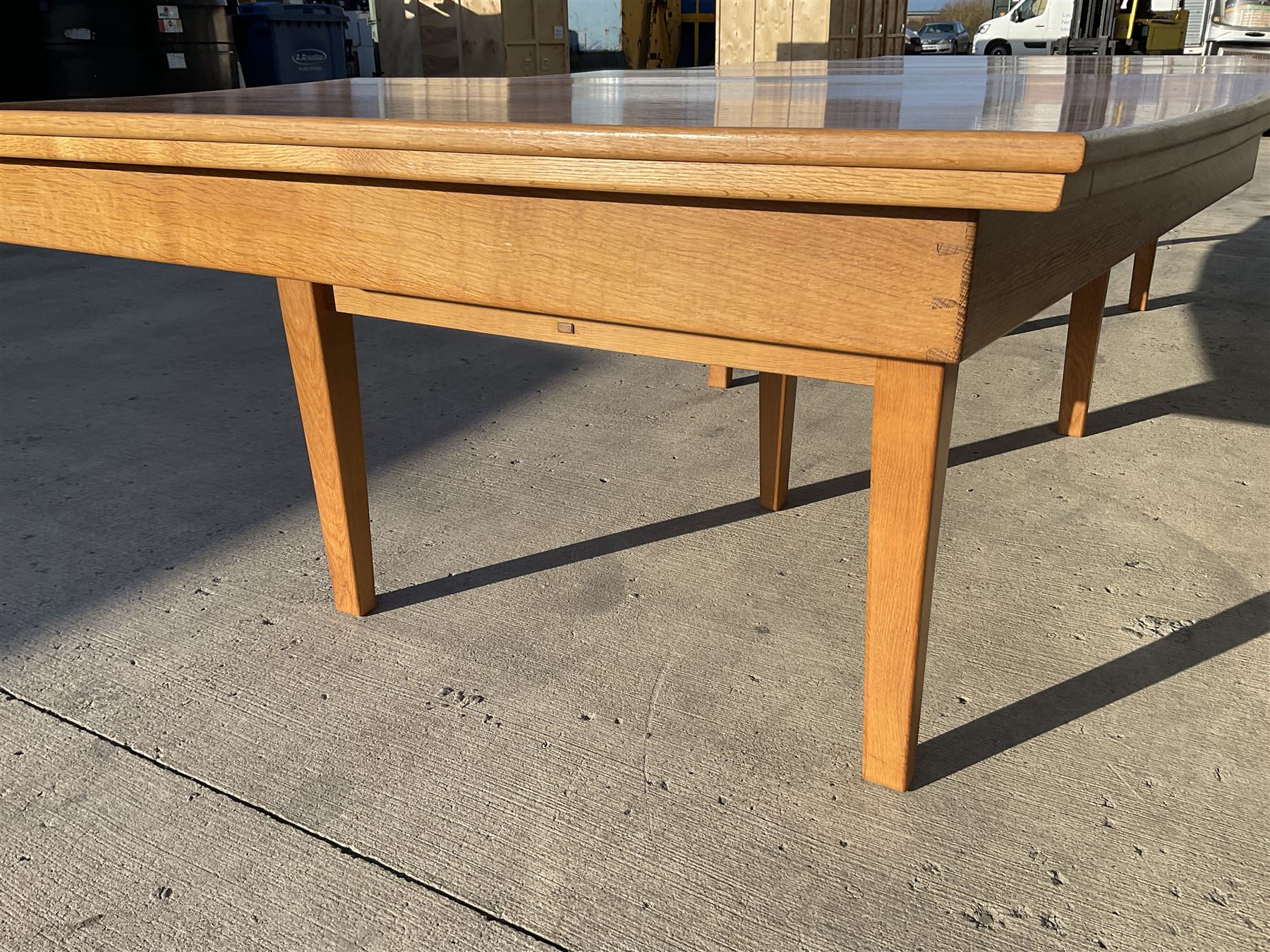 Light oak bespoke boardroom table, concave form, four sectional top on square discreet legs (12' x 5'), with twelve armchairs including 'Chairmans' chair
