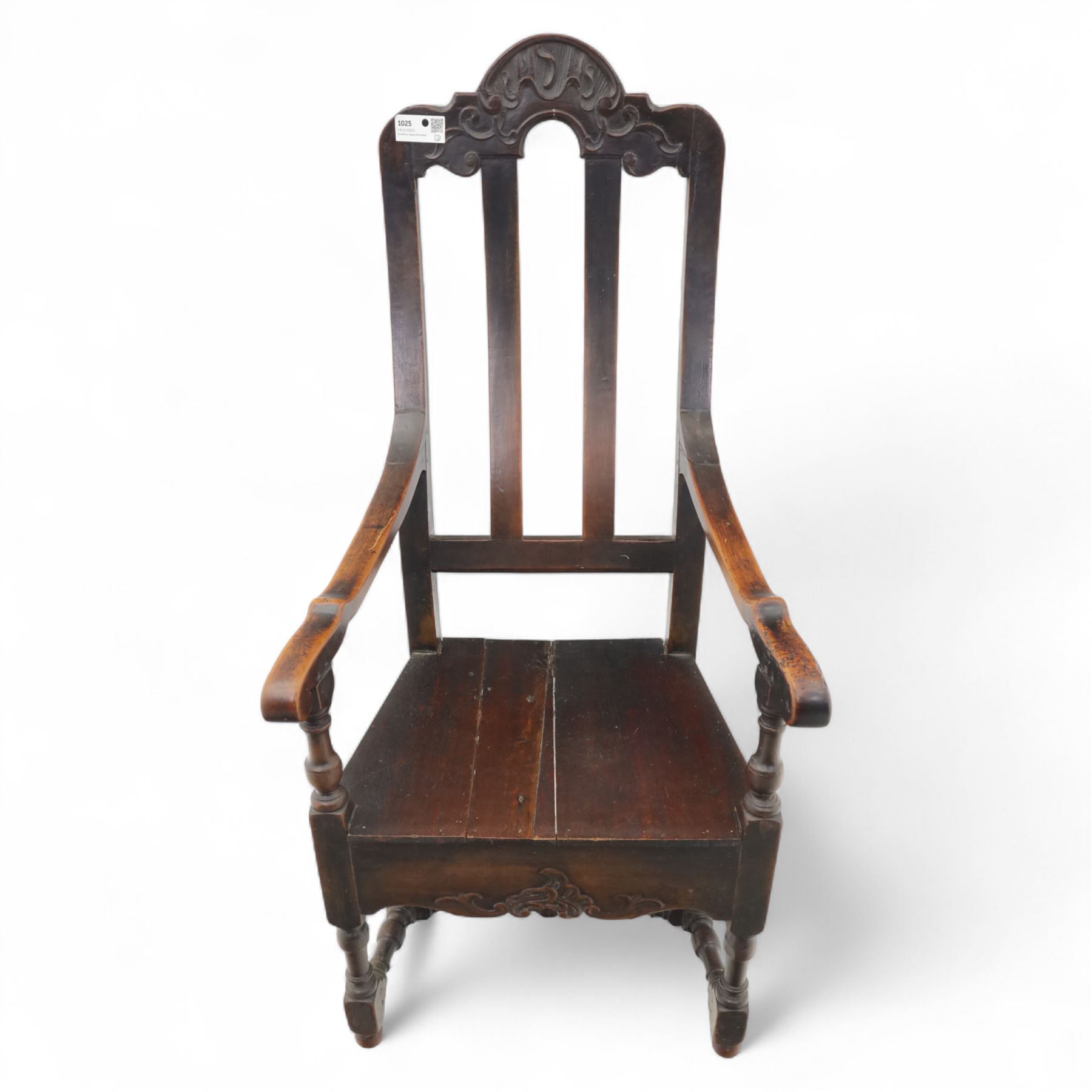 18th century oak provincial armchair, arched and carved cresting rail above triple splat back, shaped arms on turned supports, stuff-over seat upholstered in damask fabric, carved front frieze on turned legs united by stretchers