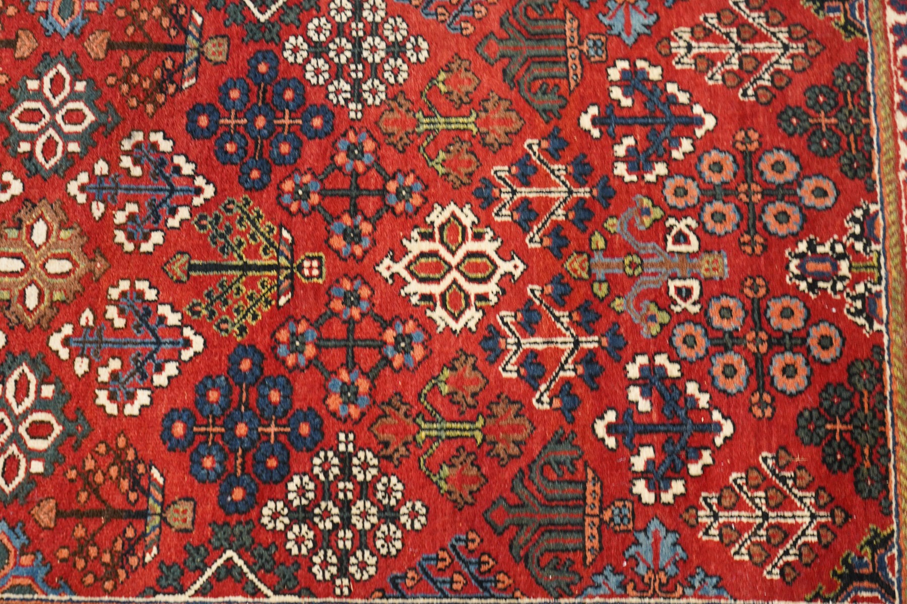 Collection of four Persian rugs, comprising a Saraband ivory ground rug with all-over boteh field and multiple borders; a crimson ground Hamadan type rug with all-over stylised floral and geometric motifs; a floral medallion prayer rug with dark field and ivory spandrels; and a Hamadan peach ground rug with repeating stylised flowering plants and dark multiple borders, largest 83cm x 142cm